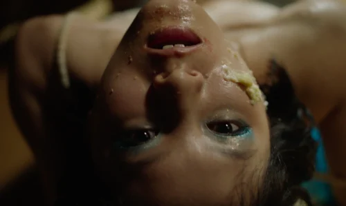 Close-up of a person lying down with tears and makeup smudged.