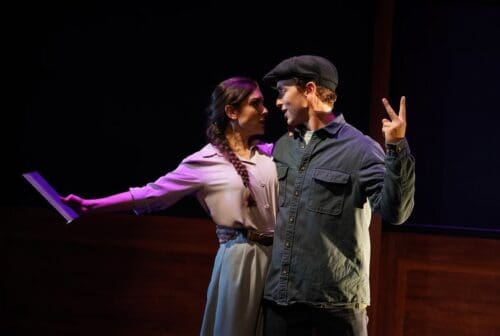 Two actors performing an emotional scene on stage with intimate expressions.