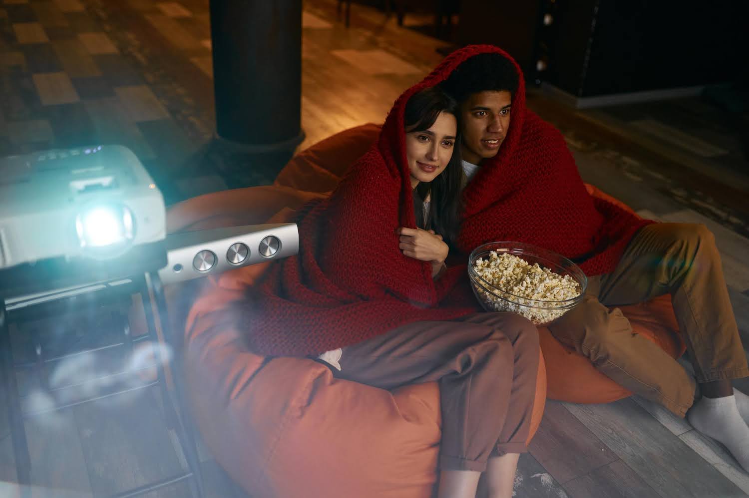 Couple watching movie with popcorn and projector at home