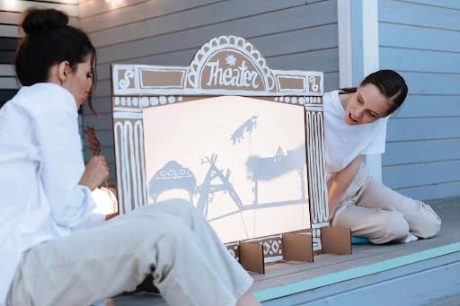 Women performing a shadow theater.