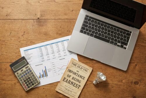 laptop-with-financial-documents,-calculator,-and-book-on-desk.